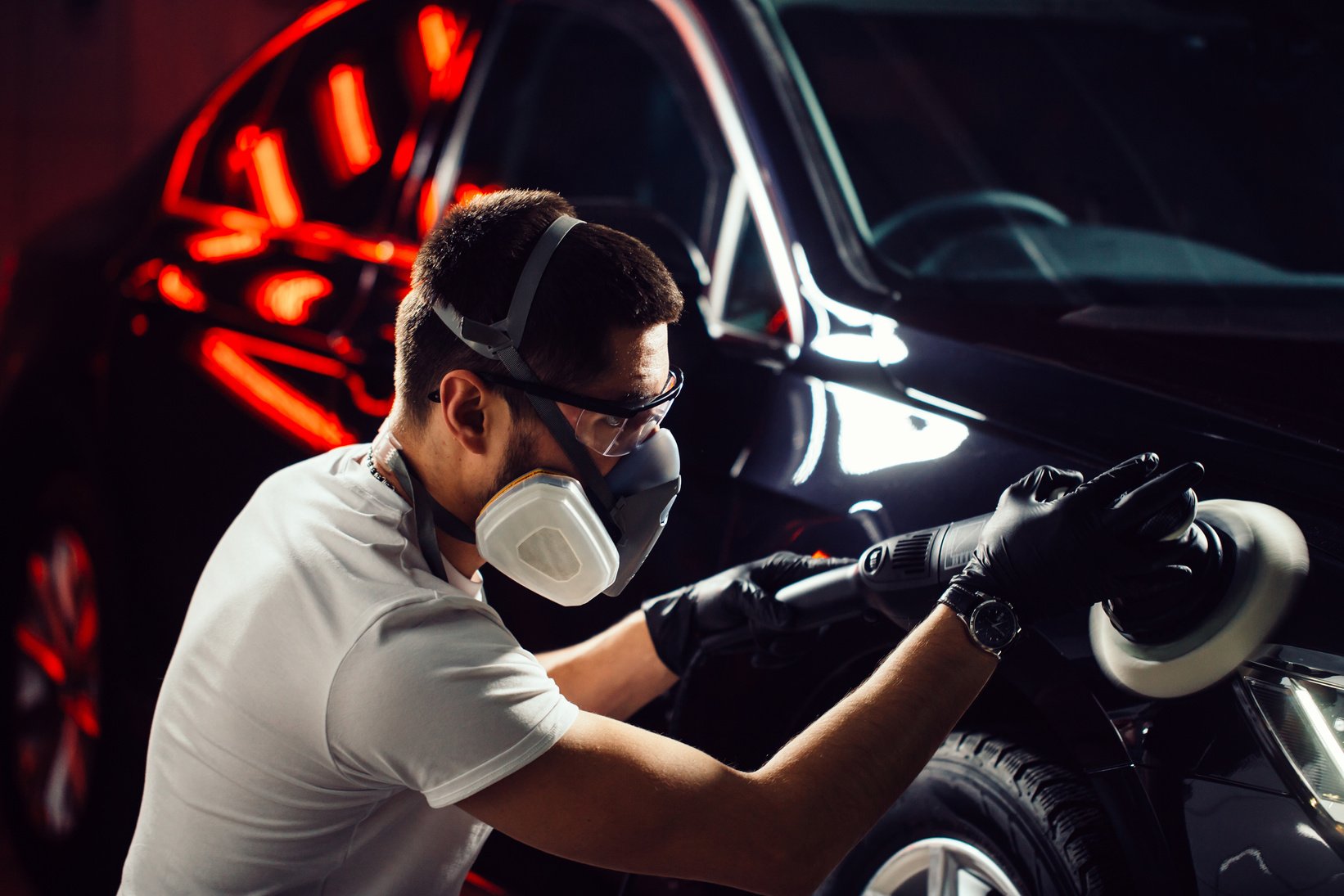 Car polish wax. worker hands holding a polisher